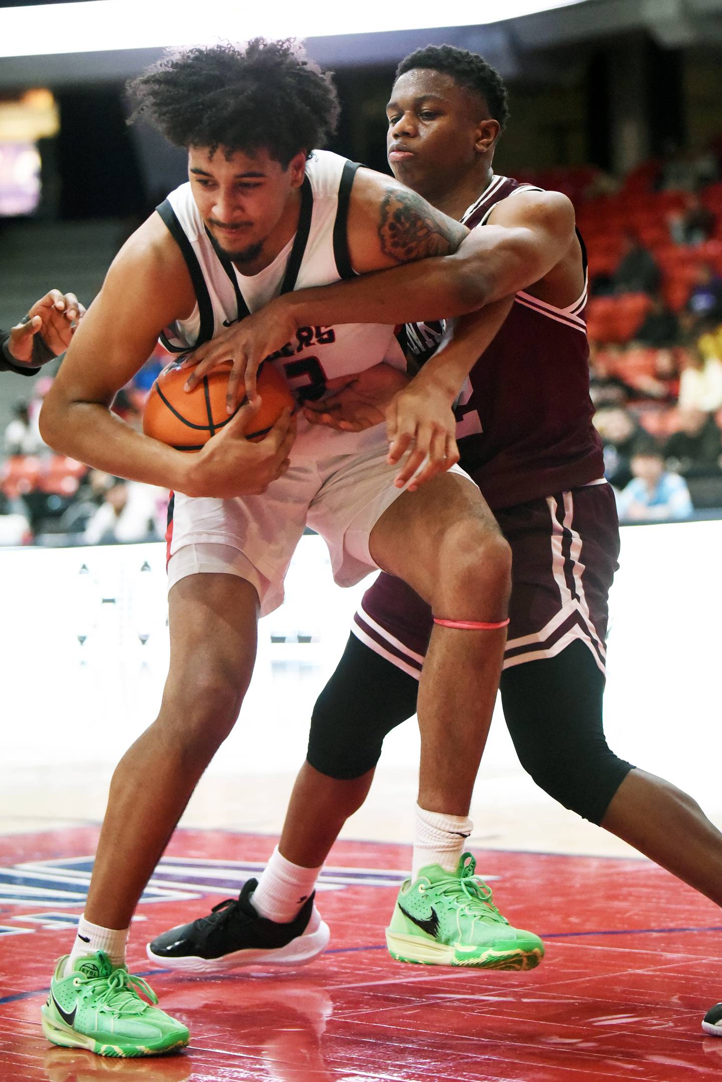 Bolingbrook's Joshua Pettigrew, left, fends off Kankakee's Myair Thompson as he grabs a rebound during Saturday's matchup in the Chicago Elite Classic at University of Illinois-Chicago's Credit Union 1 Arena.