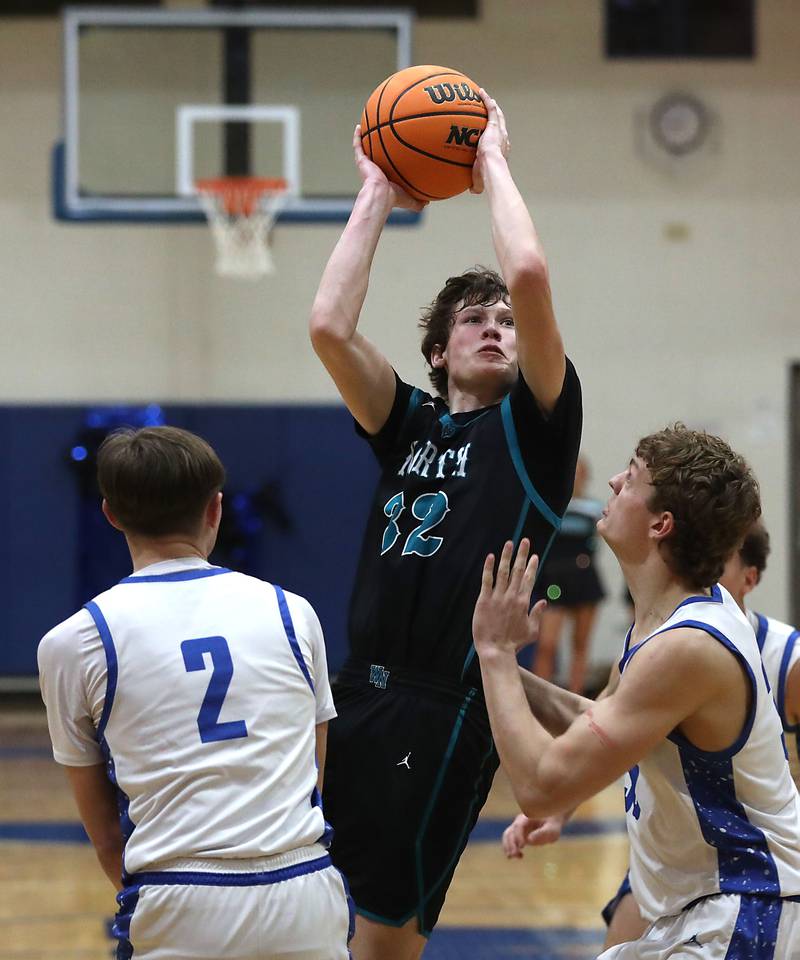 Woodstock North's Ben Hendershot shoots the ball over Woodstock's Collin Stock (left)  and Woodstock's (right) during a Kishwaukee River Conference boys basketball game on Wednesday, February. 18, 2026, at Woodstock High School.