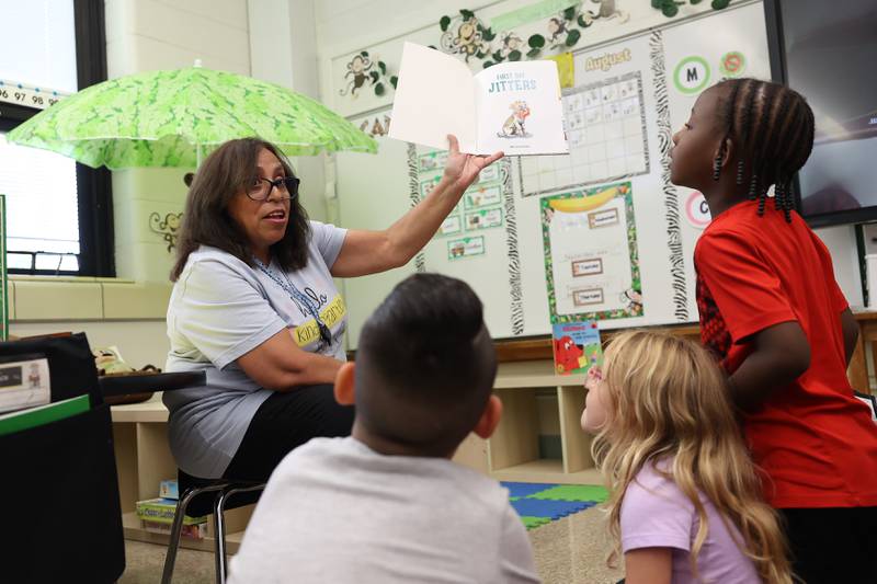 Paraprofessional Estela Paroma reads a book to the class at Taft Elementary on Wednesday, Aug. 16, 2023 in Joliet.