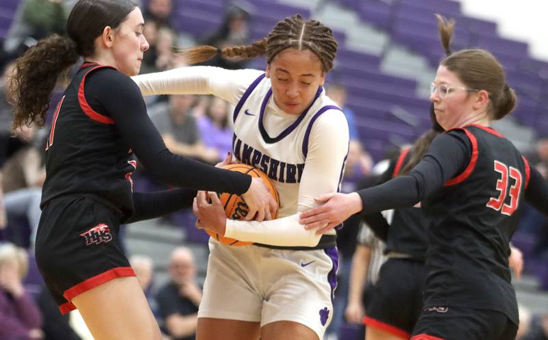 Hampshire’s Mikala Amegasse, center, fights through  Huntley’s Luca Garlin, left, and Lainey Flaws in varsity girls basketball on Wednesday, Feb. 11, 2026, at Hampshire High School in Hampshire.