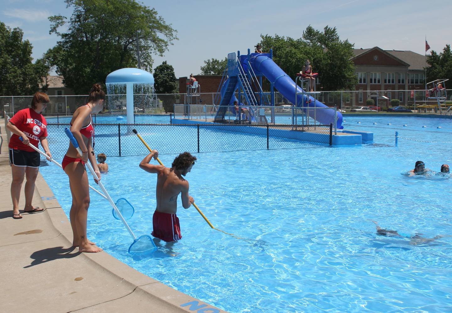 Lifeguards use skim nets to clean the surface of the water of the pool at Washington Park in Peru in it's last year of operation in 2008.