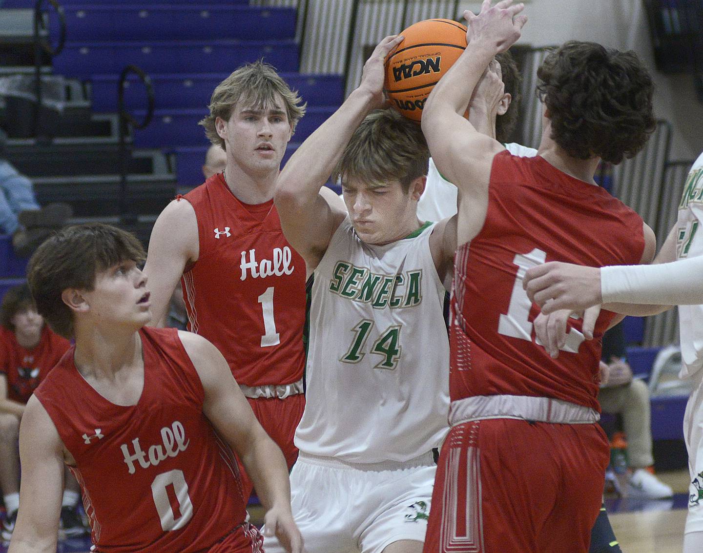 Seneca’s Cameron Shriey pulls down this rebound ahead of the Hall defense in the first period Monday at the Huskers Hardwood Tip-Off Tournament at Serena.