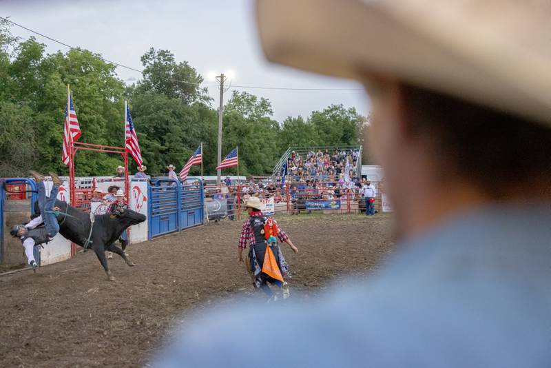 A bull rider is bucked off as judge Chris Durbin (forground) watches to score the ride during the LaSalle County 4H Fair rodeo on July 11, 2025 in Ottawa.