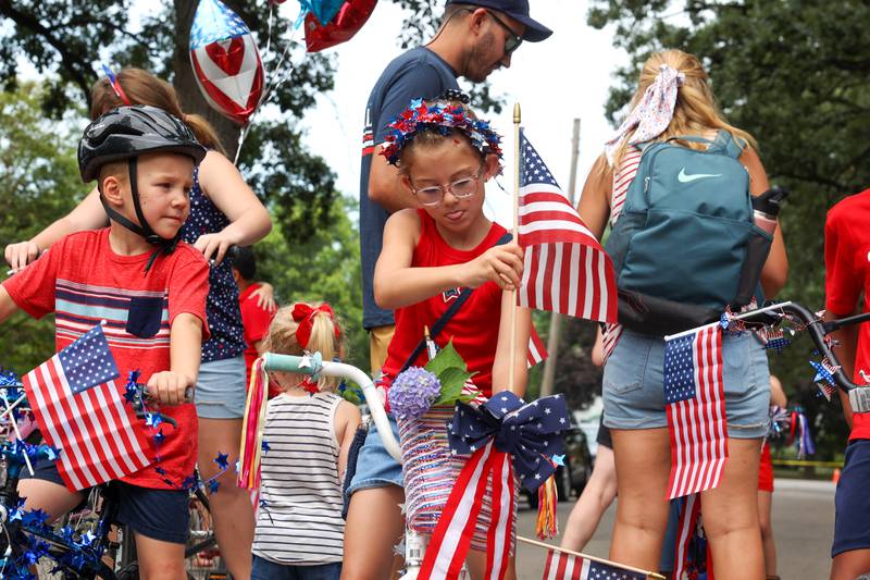 Rowan Smith, 7, of Georgetown, focuses on decorating her bike with a flag ahead of the Kids' Bike Ride during the Riverview Historic District's annual 4th of July Celebration on Friday, July 4, 2025. Smith and her cousin, Owen Vanderaa, 5, left, of St. Louis, are in town visiting family in the neighborhood.