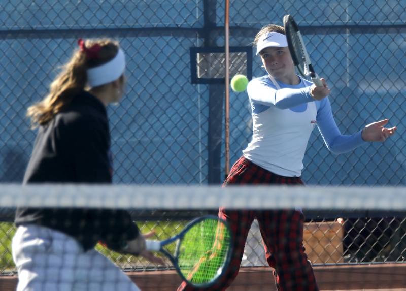 Marian Central’s Julia Lukey returns the ball as her teammate, Jenna Remke, watches on Thursday, Oct. 23, 2025, during the first day of the IHSA State Girls Tennis Tournament at Schaumburg High School.