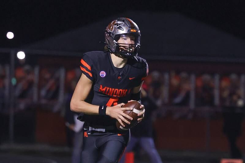 Minooka’s Zane Caves rolls out to pass against Lincoln-Way East on Friday, Nov. 8, 2024 in Minooka.