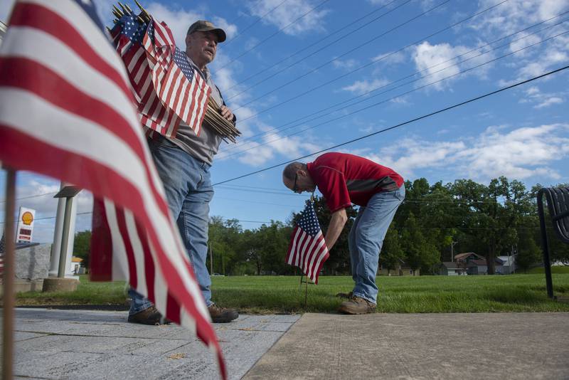 Al Wikoff (left) and Tom Bushman plant flags Friday, May 27, 2022 at Veterans Memorial Park in Dixon in recognition of Memorial Day. The group will plant 200 flags throughout the park.