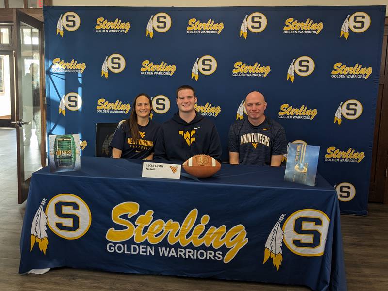 Lucas Austin (middle) sits with parents Karina (left) and Jason (right) at Sterling High School's signing day ceremony at the Sterling Schools Foundation building on Dec. 20, 2023.
