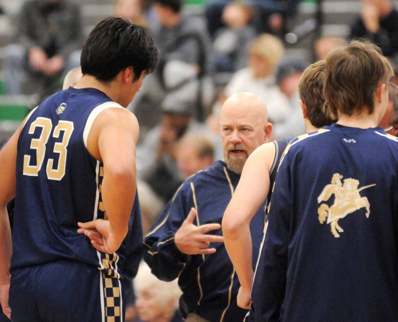 Marquette head basketball coach Todd Hopkins talks to his player Blayden Cassel during a timeout against Seneca on Friday, Dec. 5, 2025 at Seneca High School. Marquette won 53-32.