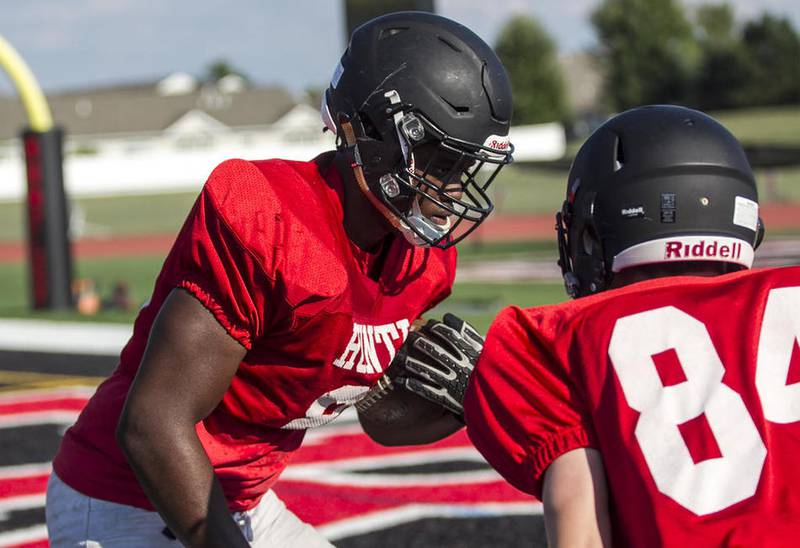 Huntley's Olalere Oladipo (left) runs the ball during football practice at Huntley High School Tuesday, August 16, 2016.