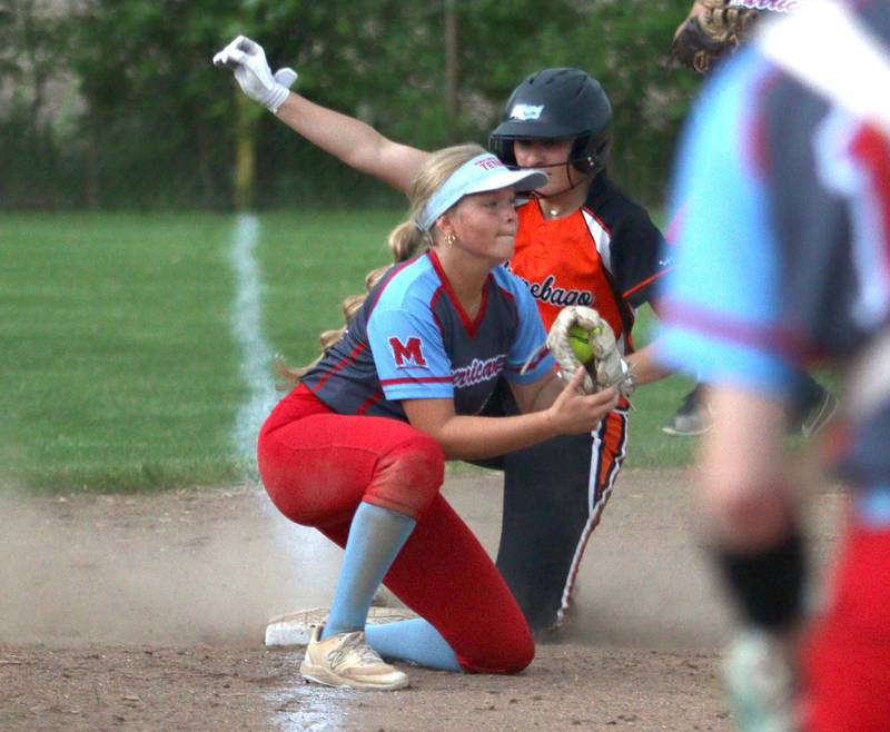 Marian Central’s Holly Garrelts  fields the throw as Winnebago’s Izzy Burd slides safely into third base during IHSA Class 2A Regional play at Raymond Benoy Field in Woodstock Monday.