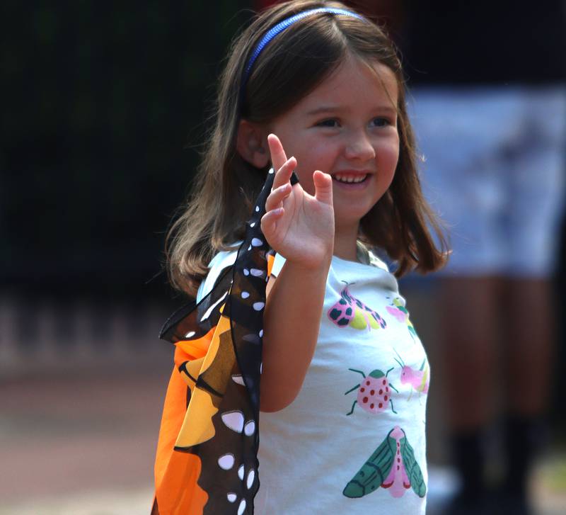 Margot Bertolami, 6, of Crystal Lake waves with her butterfly wings during Monarchs and Music at Crystal Lake Main Beach Sunday.