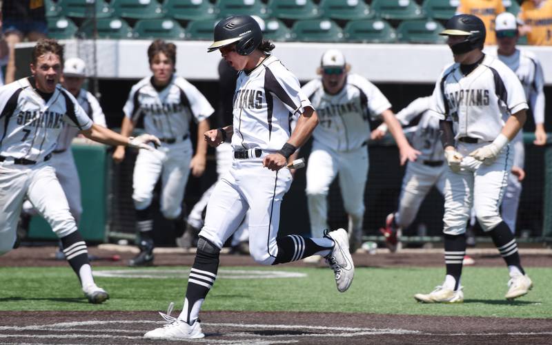 Joe Lewnard/jlewnard@dailyherald.com
Sycamore’s Will Klumpp crosses the plate with the winning run as the Spartans’ defeat Effingham 2-1 in nine innings during the Class 3A  third-place state baseball game in Joliet Saturday.