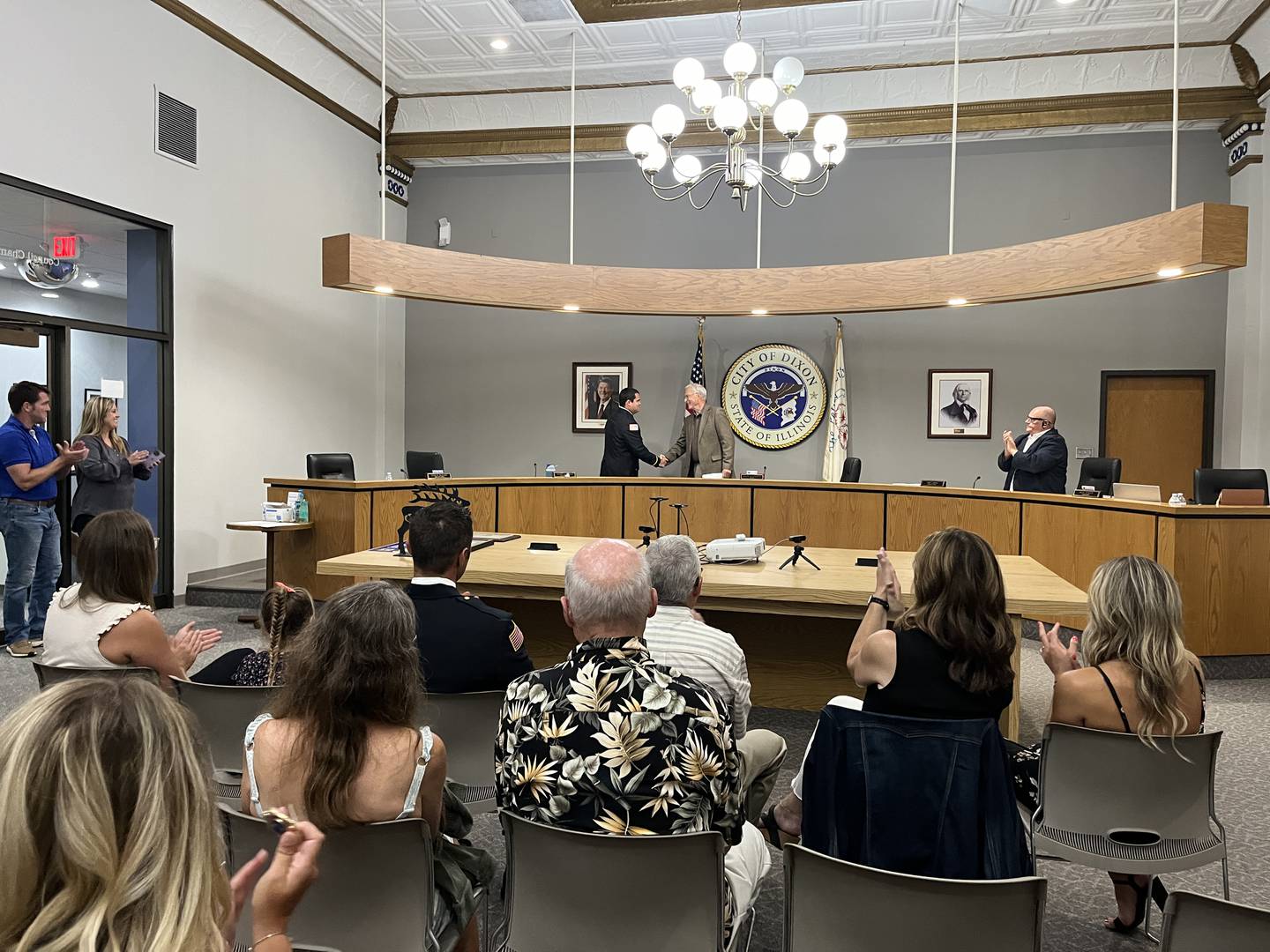Dixon City Fire Department Lieutenant Nathan McCoy (left) shakes hands with Mayor Glen Hughes (right) after he's sworn in at Monday's city council meeting. The council chambers were completely full that evening to recognize the careers of three first responders.