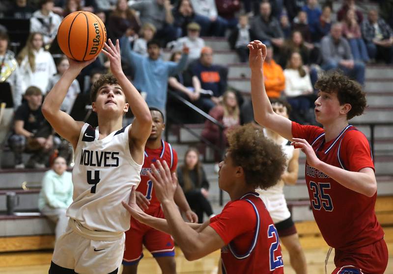 Prairie Ridge's Lucas Michalios (left) drives to the basket against Dundee-Crown's Anthony Pittman (center) and Hudson Reardon (right) during a Fox Valley Conference boys basketball game on Friday, Jan. 16, 2026, at Prairie Ridge High School in Crystal Lake.