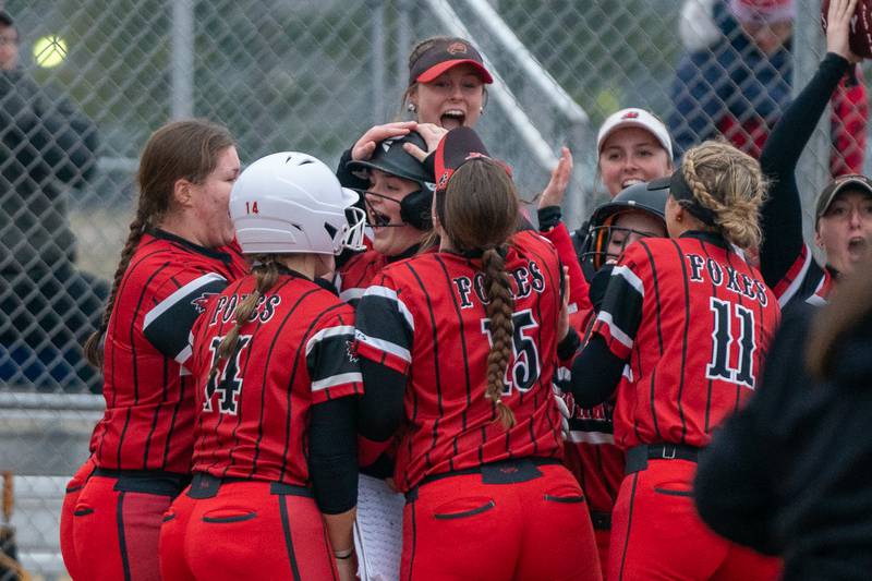 Yorkville's Kayla Kersting (center) is greeted at home by her team after hitting a homer against St.Charles East during a softball game at St.Charles East High School on Wednesday, Mar 22, 2023.