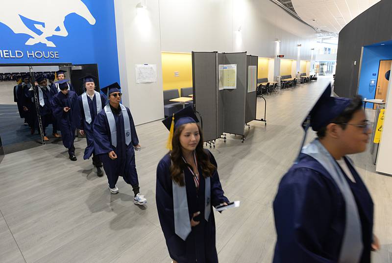 Members of the 2023 Downers Grove South graduating class walk to the football field for their graduation ceremony Sunday May 21, 2023.
