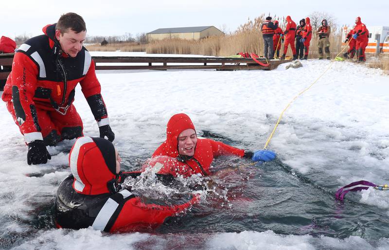 Utica firefighters (from left) Koty Gapinski, fire chief Ben Brown, and firefighter Ben Ficek, conduct an ice-rescue training drill on a private pond on Sunday, Feb. 1, 2026 south of Utica.