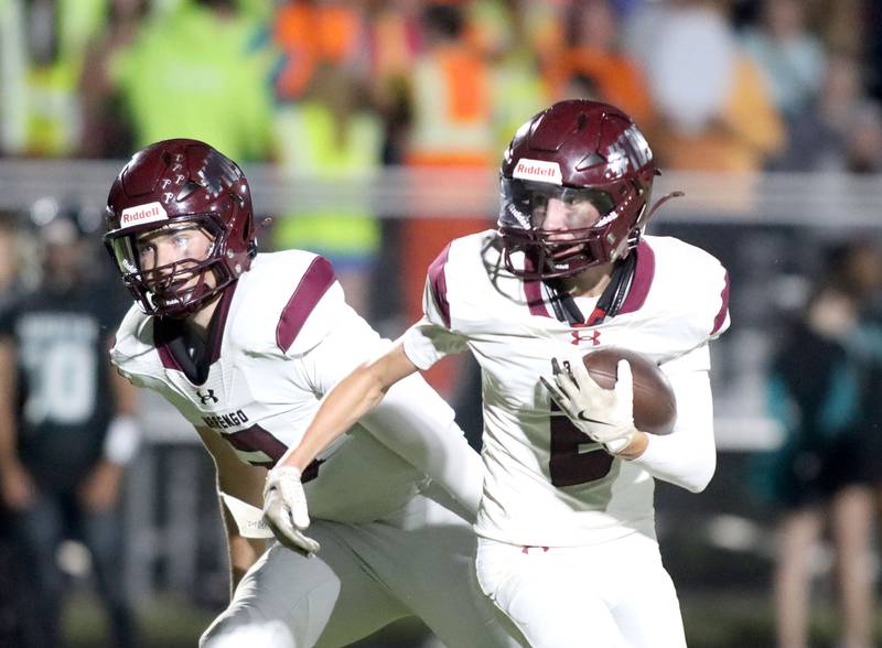 Marengo’s Cooper Lopez, right, looks for running room after grabbing a handoff from Sam Vandello against Woodstock North in varsity football at Rod Poppe Field on the campus of Marengo High School in Marengo on Friday, Sept. 12, 2025.