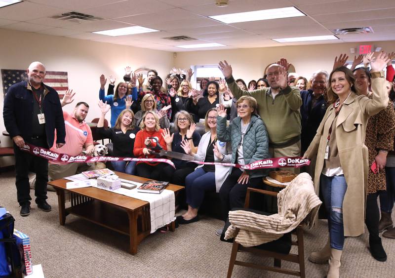 Tara Russo, executive director of Elder Care Services, cuts the ribbon Wednesday, Nov. 20, 2024, with other members of the staff and attendees at Elder Care Services’ new Cozy Corner in their facility at 1701 East Lincoln Highway in DeKalb. Cozy Corner offers seniors a community space for socializing, learning and activities.