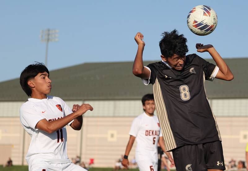 Sycamore's Ronaldo Ocelotl heads the ball away from DeKalb’s Edwin Cortina during their game Tuesday, Oct. 3, 2023, at Sycamore High School.