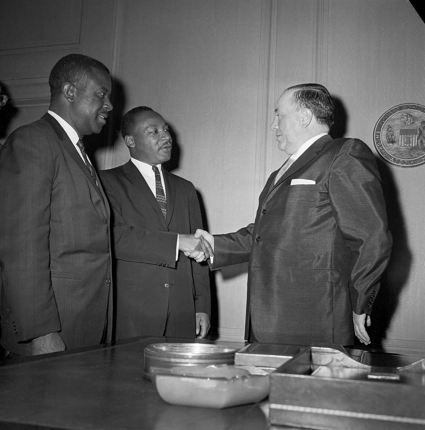 The Rev. Martin Luther King Jr. (center) shakes hands with Chicago's Mayor Richard Daley, as he visited the mayor's office with the Rev. Ralph Abernathy of Birmingham, Ala., May 27, 1963. The two civil rights leaders were in Chicago for a benefit performance to raise funds to be used to finance bail bonds for Blacks arrested in the integration movement.