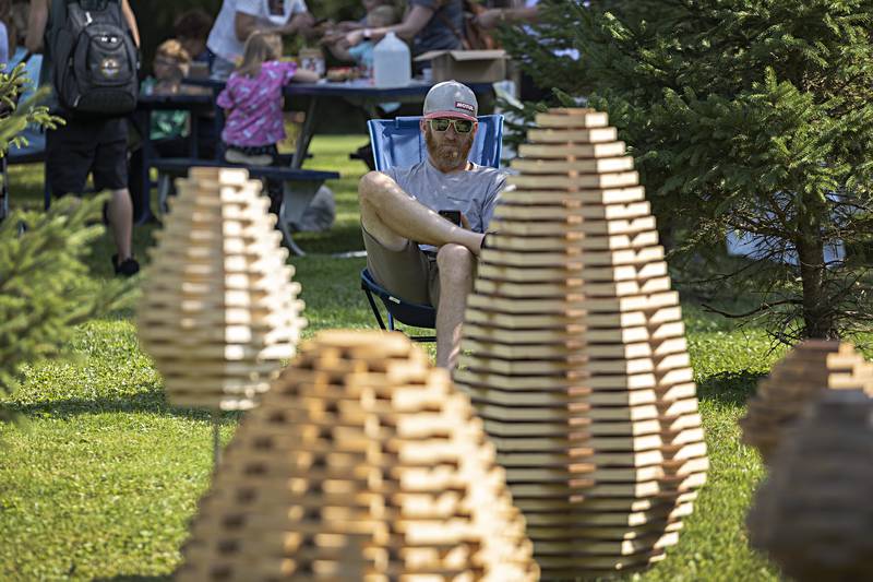 Wood artist John Carroll of Mt. Morris sits with a display of his works he calls Cairns Saturday, Sept. 23, 2023 at Lowell Park in Dixon. Carroll uses all repurposed wood, “they all had a life before,” said the artist. Lowell Park was hosting a fall fest that featured many outdoor and autumn type interests.