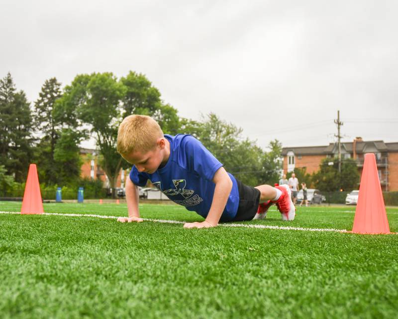 Grayson Lang, 7, of Downers Grove sees how many pushups he can do during the NFL Youth Flag Football Combine Day held at Doerhoefer Park in Downers Grove on Sunday Aug. 6, 2023.