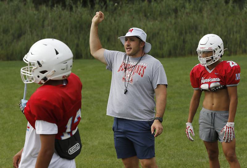 Marian Central Head Football Liam Kirwan explains to how his players how he wants them to play defense during football practice on Tuesday, August 19, 2025, at Marian Central  High School in Woodstock.