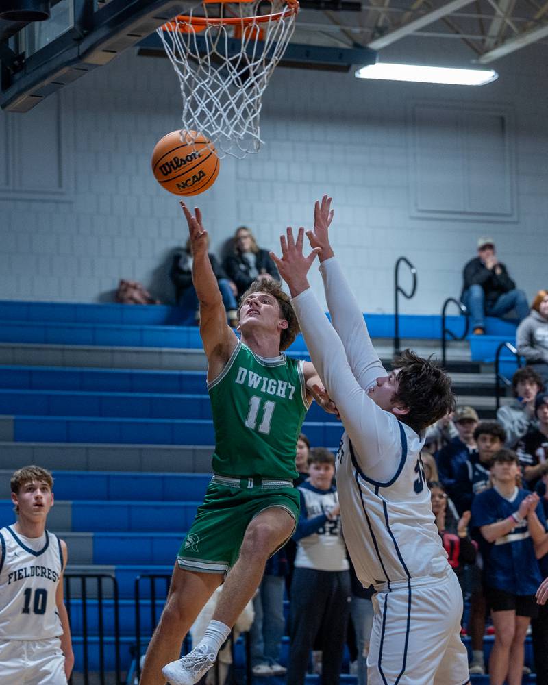 Joey Starks (11) of Dwight lays ball up as Drew Overocker (31) of Fieldcrest attempts to contest on Monday, December 15, 2025 at Fieldcrest High School in Minonk.