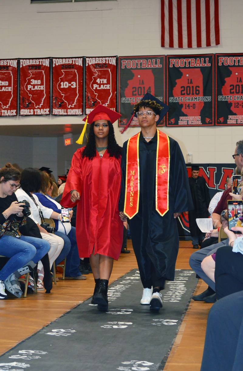 Siblings McKenna and McKeon Crase hold hands as they enter the Forreston High School gym where the Class of 2023's commencement was held on May 14, 2023. McKenna plans to study business at Highland Community College; McKeon is joining the U.S. Marine Corps.