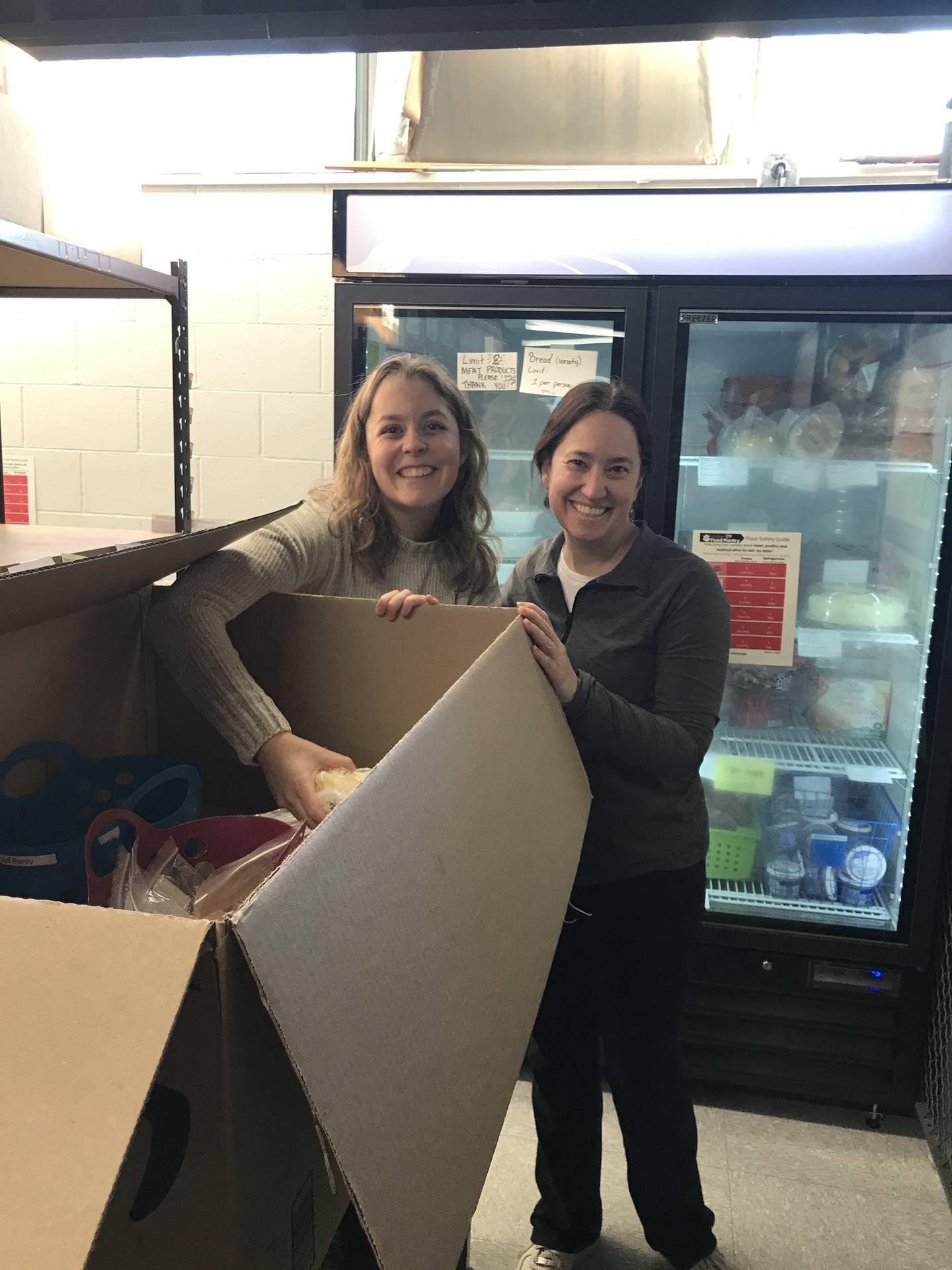 Dietetic intern Emilee Williams, left, and Nancy Prange, the director of dietetic interns, hold a box while working on the Huskie Harvest program. Photo provided by Northern Illinois University.