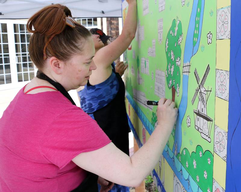 Kathryn Fredrickson, from Geneva, works on the Geneva Chamber of Commerce’s paint-by-number community art project Saturday, July 26, 2025, during at the Geneva Arts Fair on Third Street in Geneva.