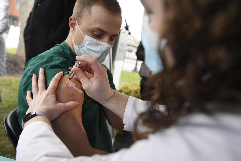 Colleen Teevan, System Pharmacy Clinical Manager at Hartford HealthCare, administers the Pfizer-BioNTech vaccine for COVID-19 to healthcare worker Connor Paleski outside of Hartford Hospital, Monday, Dec. 14, 2020, in Hartford, Conn. (AP Photo/Jessica Hill)