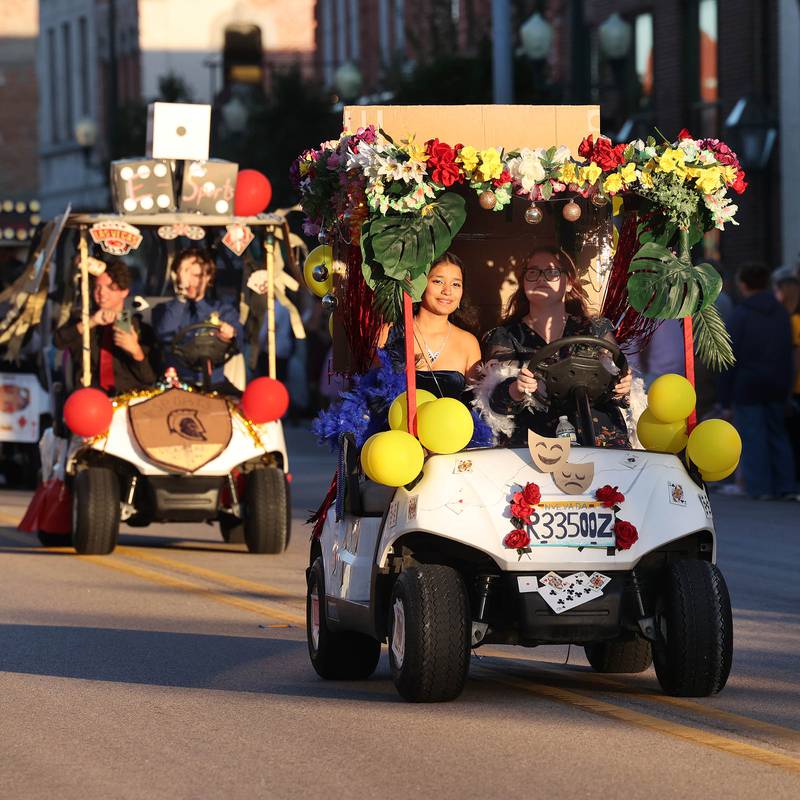 Some of the golf carts decorated by the various school clubs head down State Street Wednesday, Sept. 25, 2024, during the Sycamore High School homecoming parade.