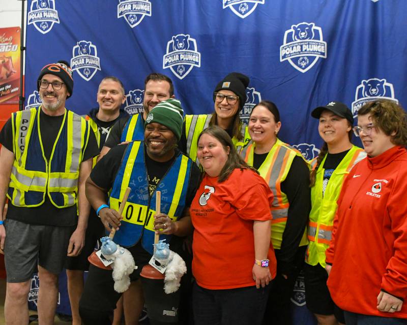 Sycamore police’s department pose for a photo along with Shelby Edward and Lisa Steinbis after receiving the Law enforcement torch run as well as the Team Spirit award before the start of the Polar Plunge event on Saturday Feb. 21, 2026, held at Huskie Stadium in DeKalb.