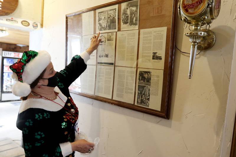 General Store employee Sharon Consentino points out a board inside the store that details a lot of the building's and the township's history on Tuesday, Dec. 15, 2020, in Greenwood. The building has been a general store since its construction in 1894 and was also the township's post office.