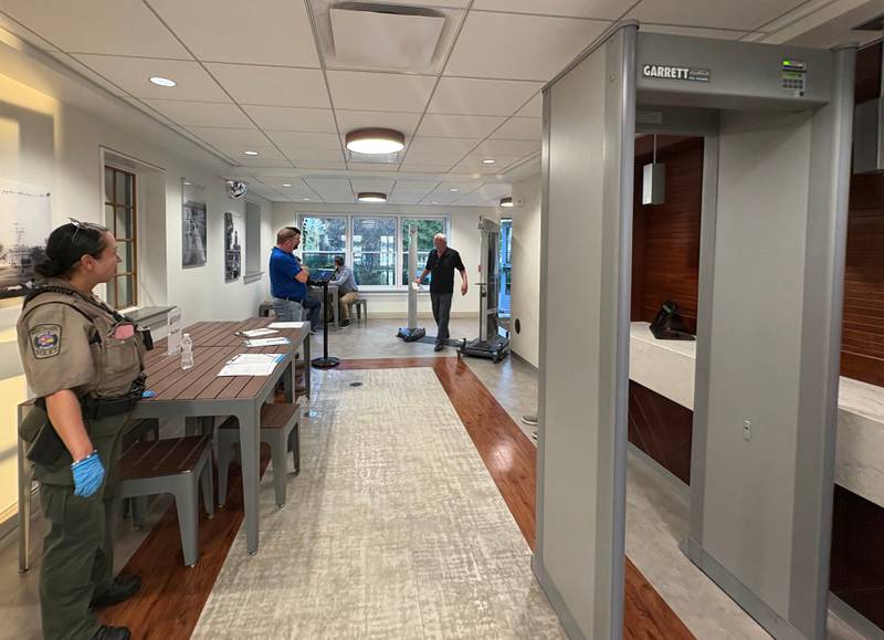 A Crystal Lake Park District police officer stands next to a metal detector set up for a park board meeting Sept. 22, 2025., prompted by security concerns.
