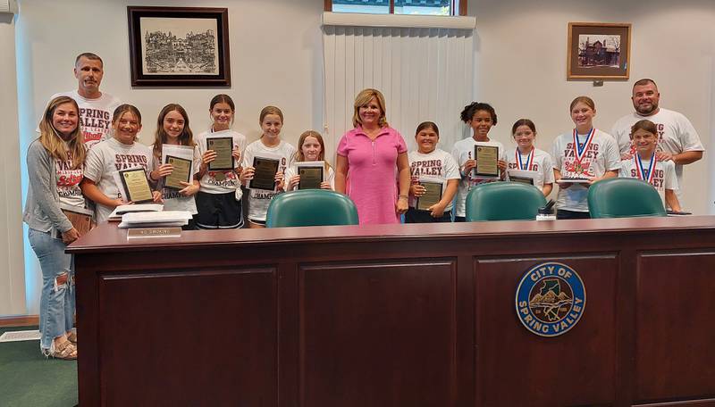 The Spring Valley Minor League softball state championship team poses for a photo with their coaches and Mayor Melanie Malooley-Thompson (in pink) on Monday, Aug. 7, 2023, at the Spring Valley Council Chambers.