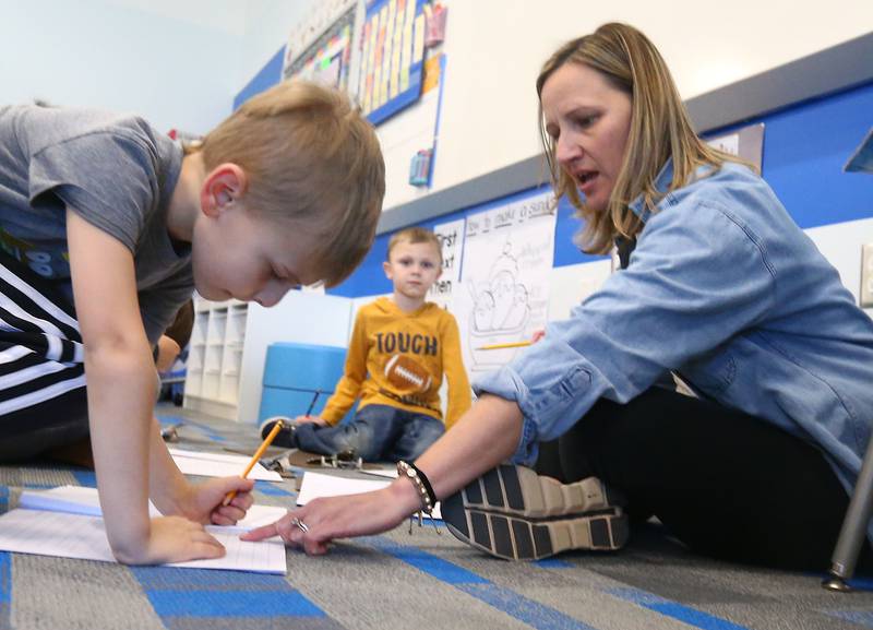 Mrs. Karin Kummer, a kindergartner teacher at Waltham School, teaches student Patrick Daley how to write numbers and letters on Tuesday, March 8, 2022 in Utica.