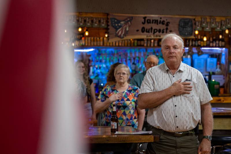 Larry Langston covers heart during pledge of allegiance at the 'Guns Save Life' event on Thursday, Aug 21, 2025 at Jamie's Outpost in Utica.