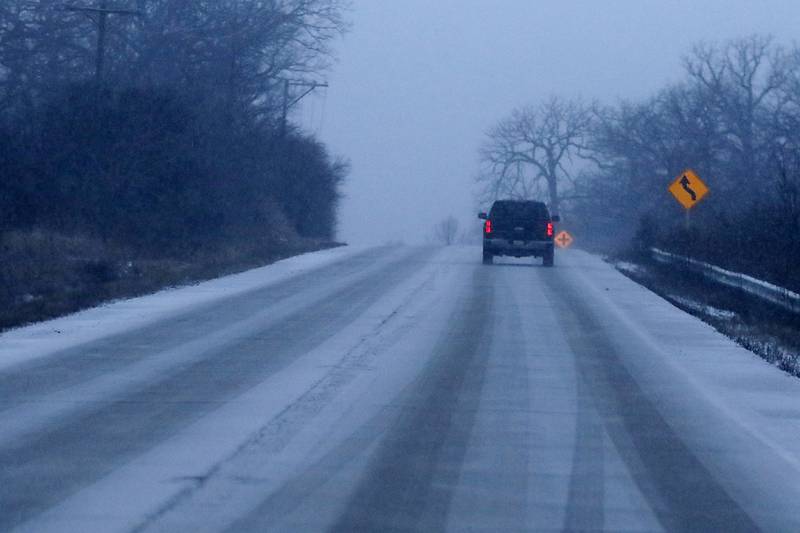 A vehicle navigates a snow covered Illinois Route 173 on Wednesday, Jan. 22, 2025, near Richmond.
