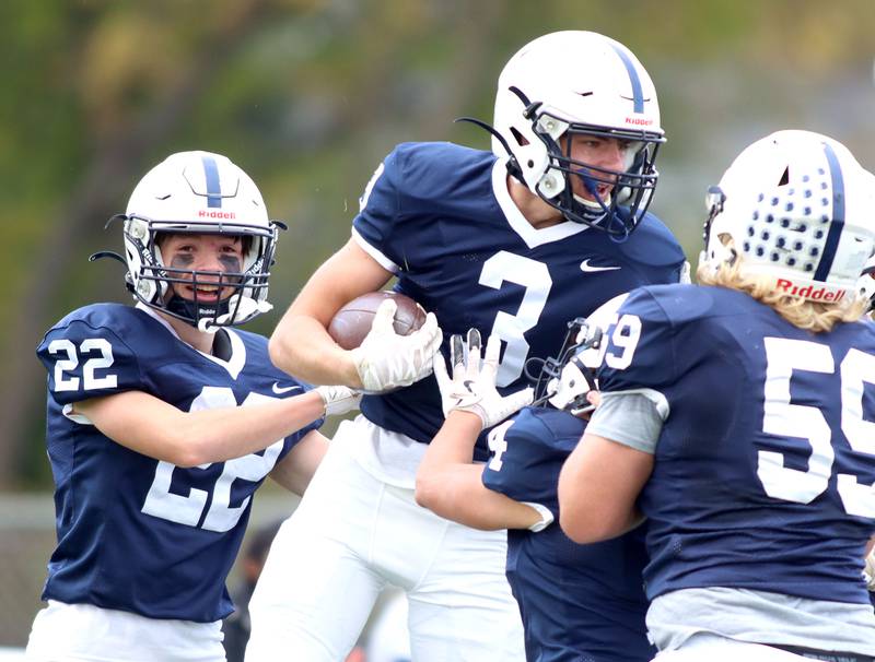 Cary-Grove’s Ty Tenopir, center, is mobbed by the Trojans after a touchdown against Sycamore in IHSA football Class 5A first-round playoff action at Al Bohrer Field on the campus of Cary-Grove High School in Cary on Saturday, November 1, 2025.