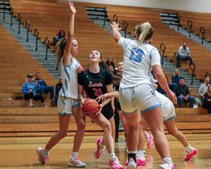 St Charles East's Sofia O’sullivan (21) splits the defense while driving to the basket at the York Thanksgiving Tournament. Nov 13, 2023.