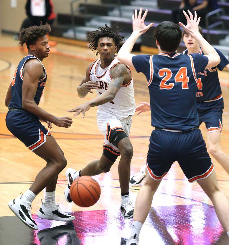 DeKalb's Darrell Island passes the ball between two Naperville North defenders during their game Monday, Jan. 30, 2023, at DeKalb High School.