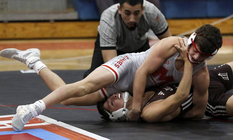 Marian Central's Nicholas Marchese tries to pin Joliet Catholic's Andrew Staab in their 132-pound match during a triangle wrestling meet on Saturday Jan. 11, 2025, between Marian Central, Joliet Catholic, and Mt. Carmel at Marian Central High School in Woodstock.
