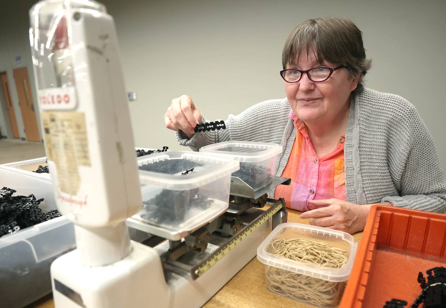Sheila Buchholz, a client of Opportunity House, carefully weighs connectors Thursday, May 11, 2023, in OH Industries, at the Opportunity House facility in Sycamore. OH Industries offers packaging and light assembly services for local companies performed by Opportunity House clients with intellectual and developmental disabilities.