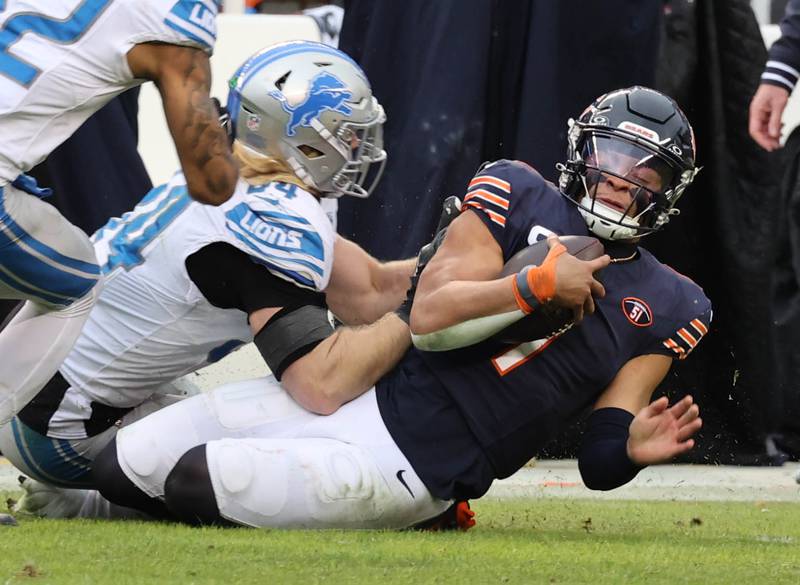 Chicago Bears quarterback Justin Fields is hit as he slides by Detroit Lions linebacker Alex Anzalone during their game Sunday, Dec. 10, 2023 at Soldier Field in Chicago.