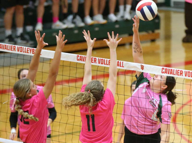 St. Bede's Bella Pinter spikes the ball past L-P's Kelsey Frederick and Katie Sowers during the "Cavs 4 A Cause" pink night game on Tuesday, Sept. 26, 2023 at Sellett Gymnasium.