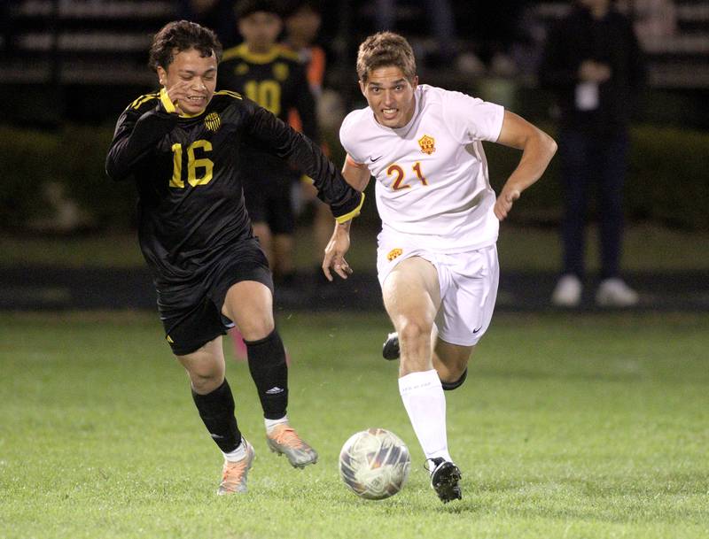 Harvard’s Kevin Contreras, left, and Richmond-Burton’s Aidan Albert sprint for the ball in varsity soccer on Monday, Oct. 7, 2024, at Dan Horne Field on the campus of Harvard High School in Harvard.
